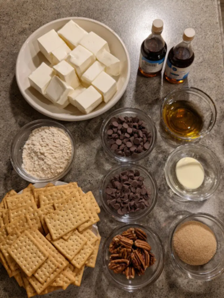 Flat lay of ingredients for Christmas Crack including saltine crackers, butter, brown sugar, vanilla, chocolate chips, and pecans on kitchen counter