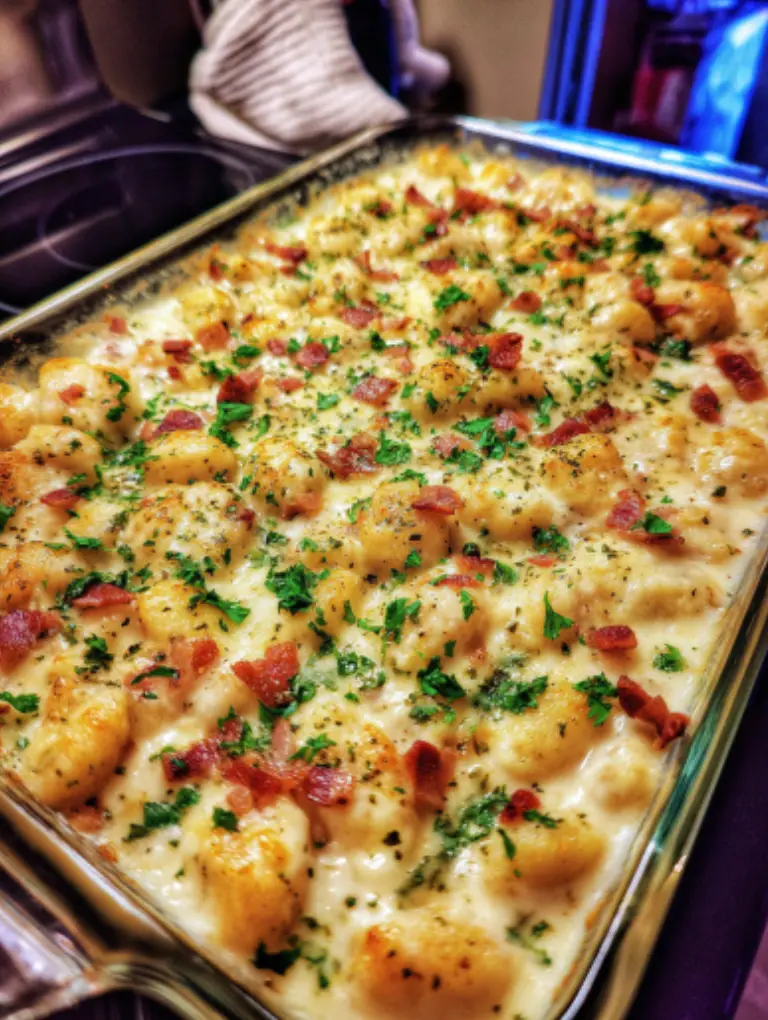 Flat lay of creamy crack chicken gnocchi served in white bowls on the kitchen counter with parsley garnish and a spoon beside.