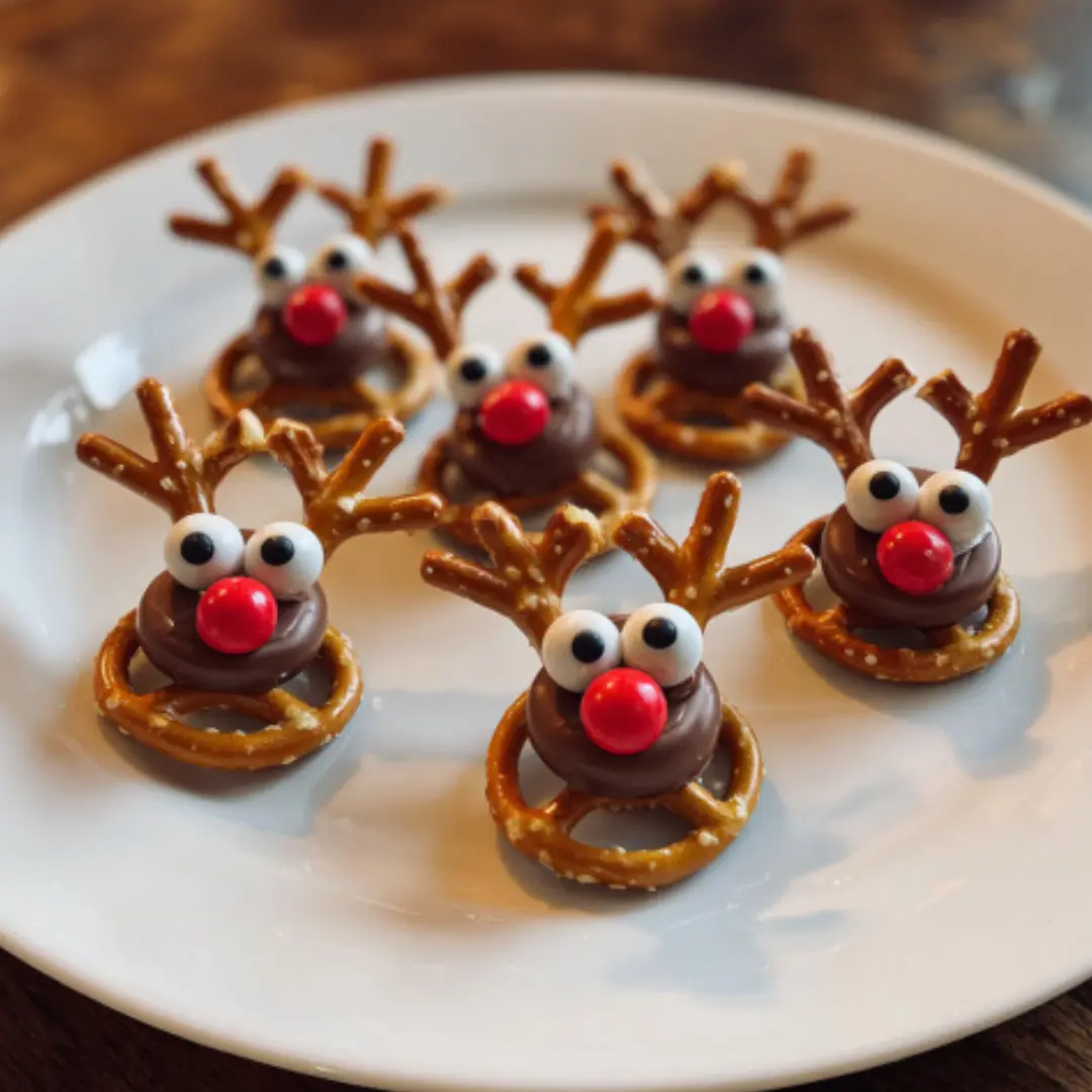 Mini pretzel Rolo monsters with candy eyes and red candy noses on a gray kitchen countertop
