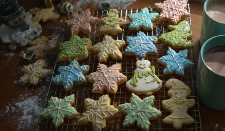Homemade Christmas cookie dough with cutters, flour, and butter on a kitchen counter.