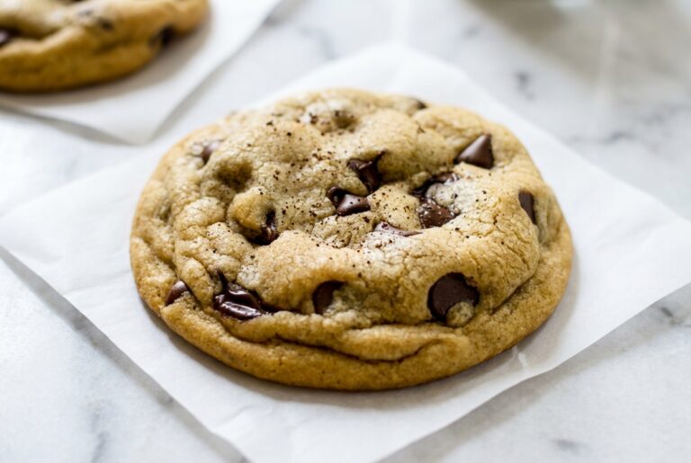 Golden chocolate chip cookies recipe with beurre noisette and espresso on a white marble surface under natural window lighting.
